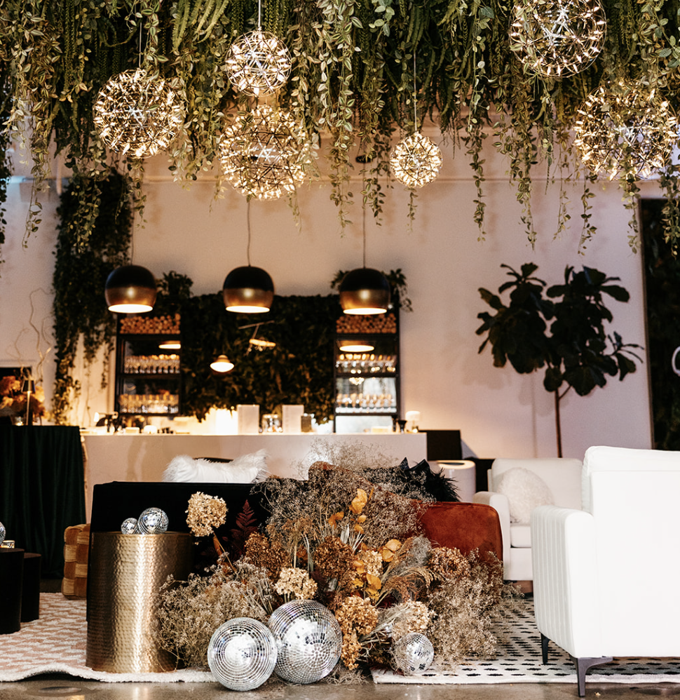 Lounge and bar area with greenery and disco balls at Urban Daisy